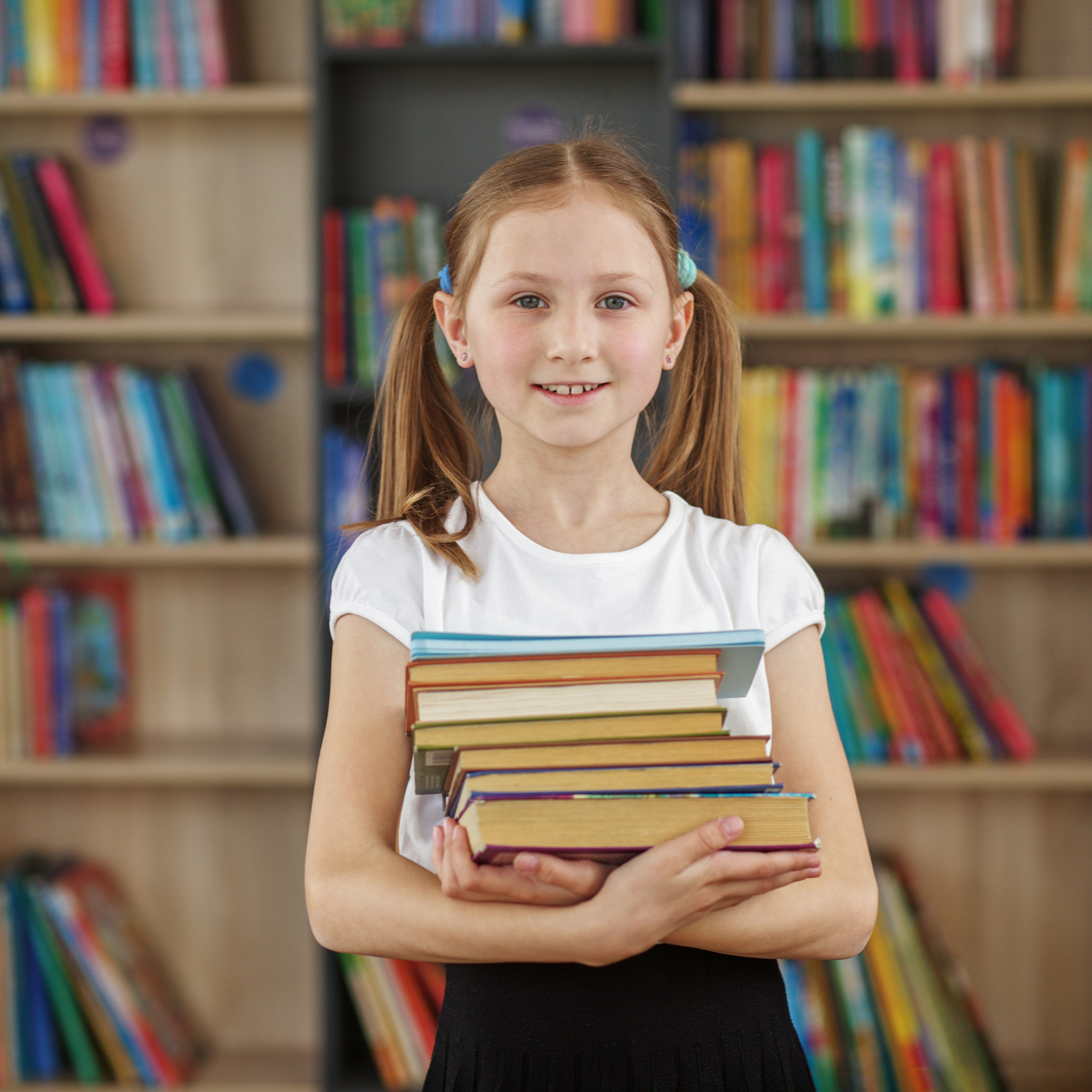 A child holding a lot of books representing the opportunity to purchase self published author and illustrator Lindsay Dain's creations from Amazon KDP and Kindle Direct Publishing in bulk for a discounted price.