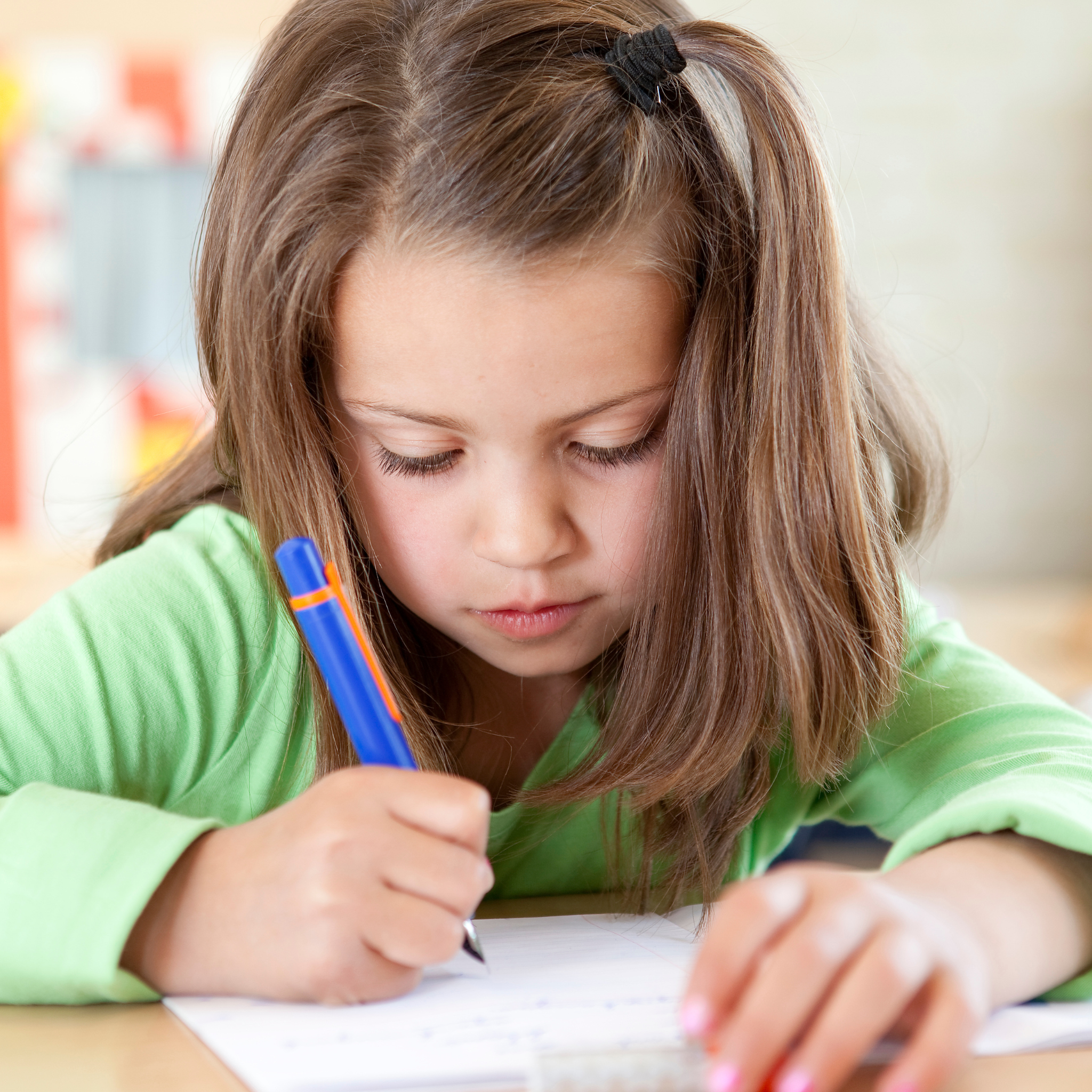 A picture of a girl practicing handwriting using the self published Bible Verse Handwriting Book created through Kindle Direct Publishing