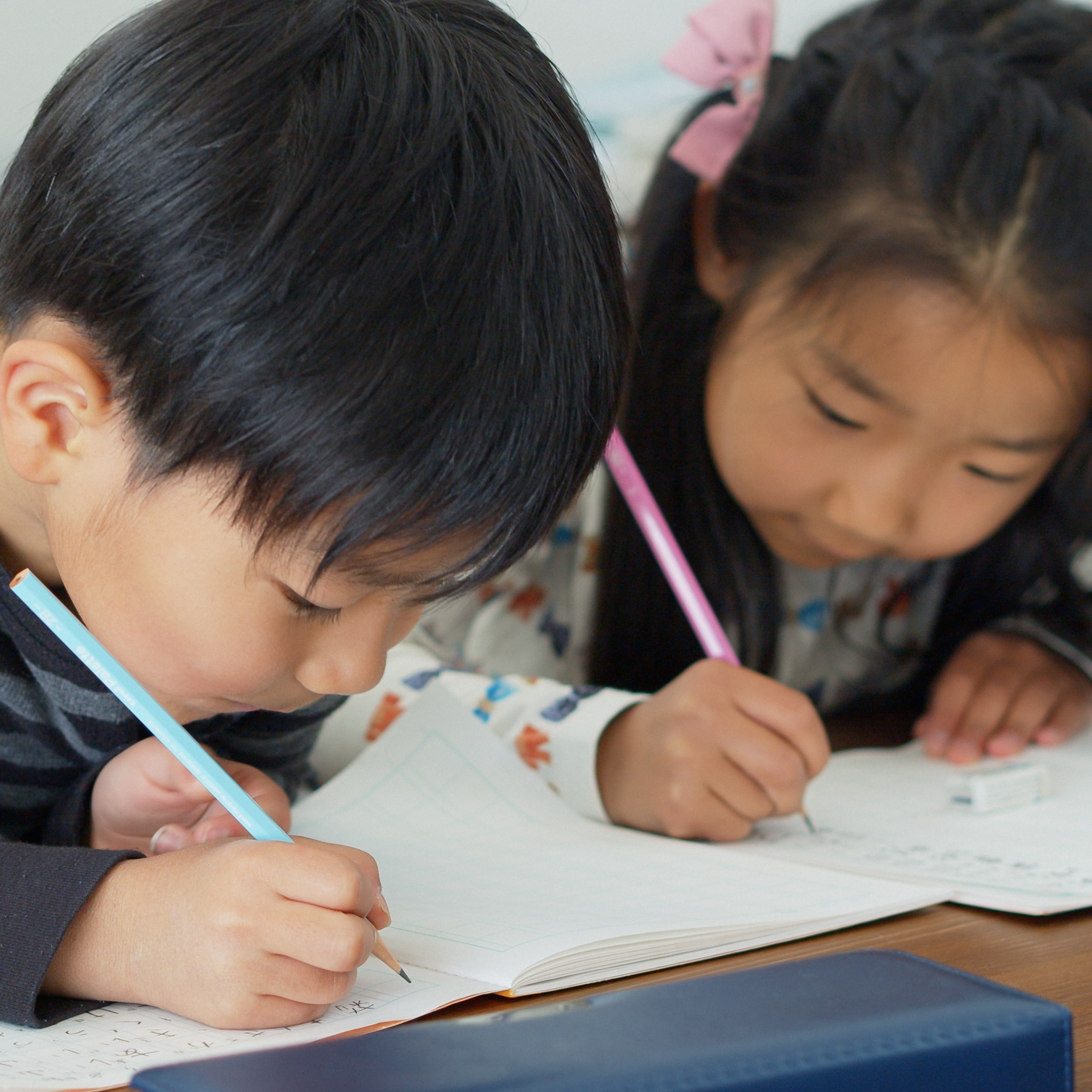 Photo of children practicing handwriting skills with the self published Bible Verse Handwriting Workbooks created on Amazon KDP