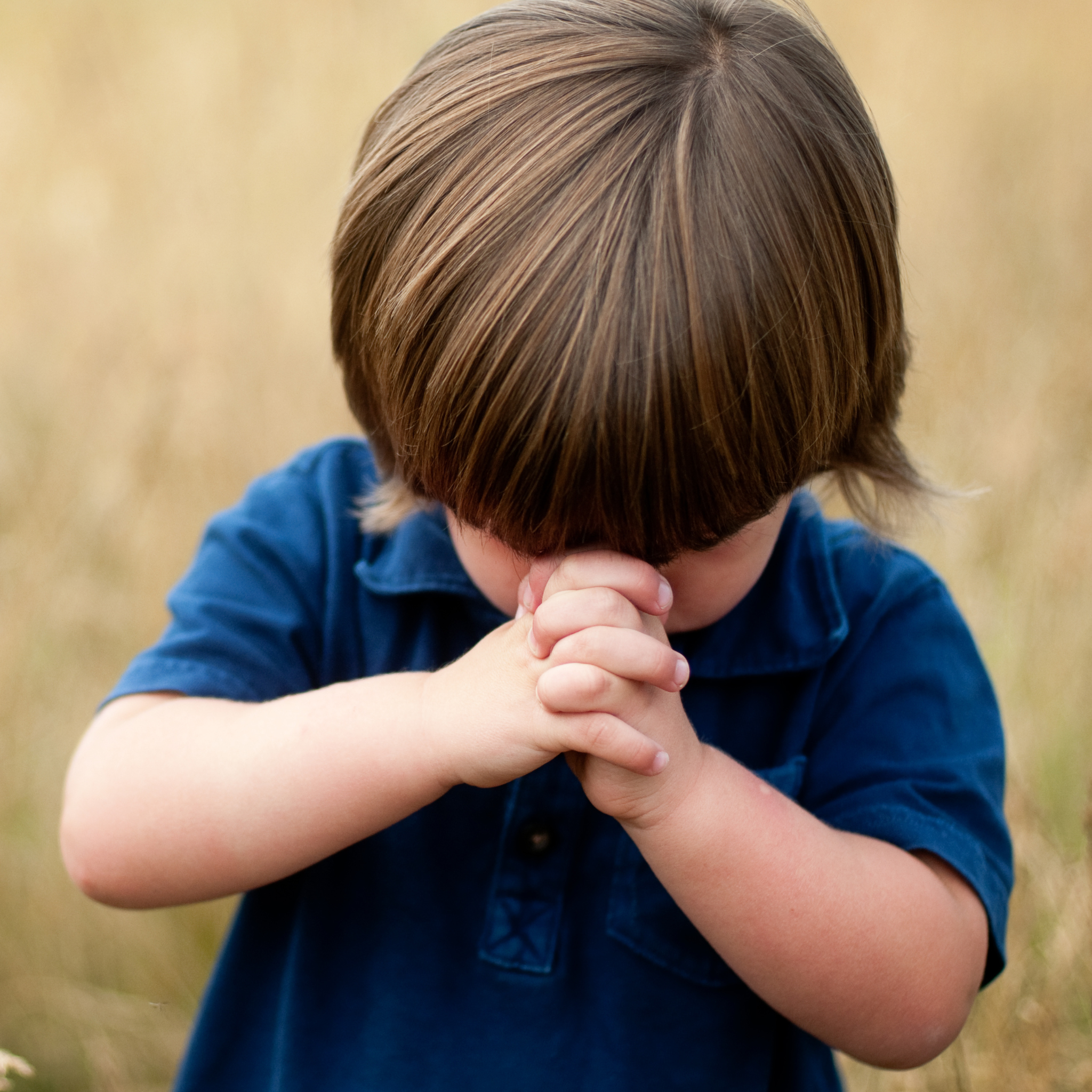 A photo of a boy praying to God. The Bible Verse Handwriting Book speaks to the hearts of children with its first person writing style.